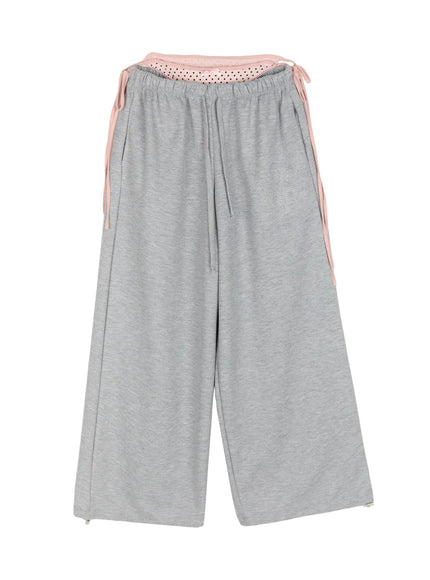 Dot Print Sagging Sweatpants IL515 Gray flat-lay front showing full silhouette with pink polka dot layered waistband side ribbon ties rhinestone logo and zip hem