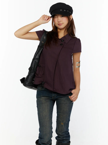 Double-Button Short Sleeve Blouse CL515 dark purple front view model winking holding baker boy cap carrying black leather bag with arm cuff accessory