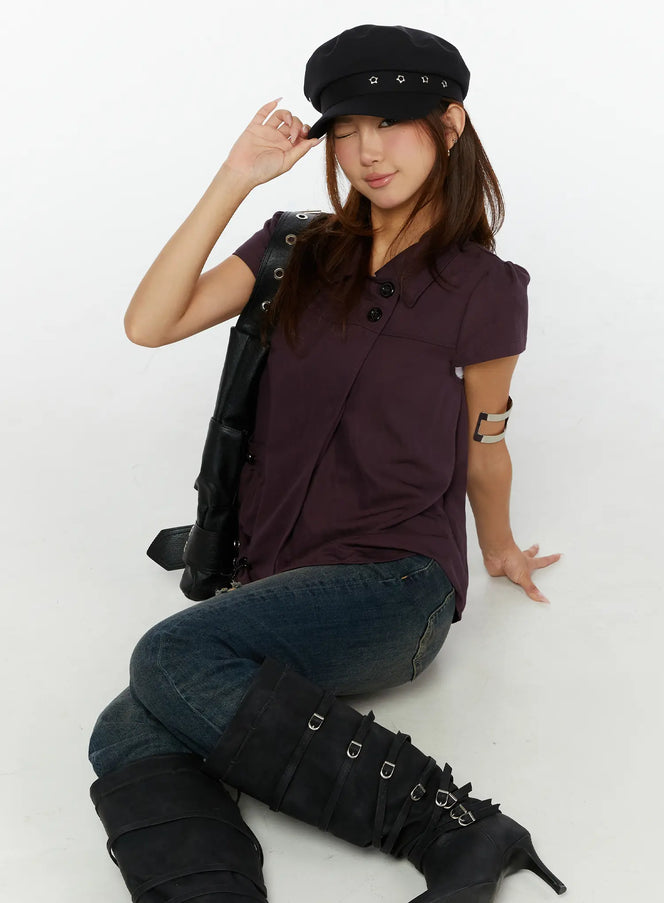 LEWKIN Double-Button Short Sleeve Blouse CL515 dark purple model seated pose styled with black baker boy cap leather bag and buckle boots