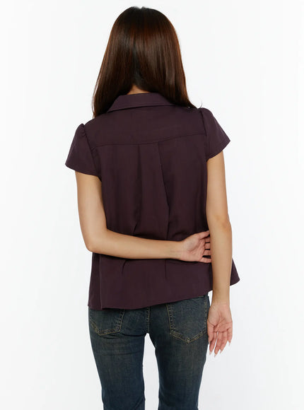 Double-Button Short Sleeve Blouse CL515 dark purple back view model standing arms behind showing back pleat yoke seam and curved hem with jeans