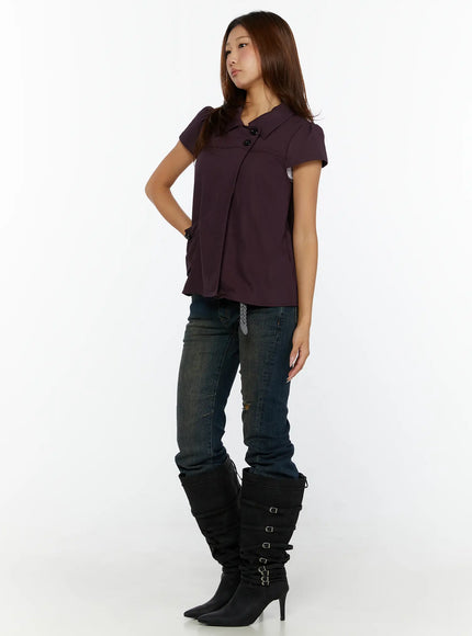 Double-Button Short Sleeve Blouse CL515 dark purple side view model standing looking away showing asymmetric hem and button closure detail with boots