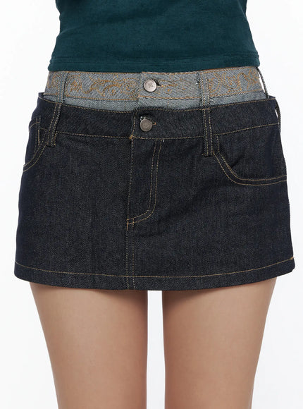 Double-Layered Back Embroidered Denim Mini Skirt CL513 dark indigo close-up front waist detail showing jacquard double-layered waistband and metal button