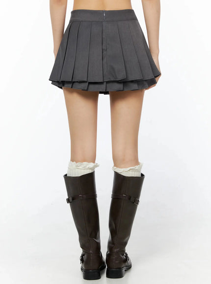 Double Pleated Mini Skirt IL509 Dark gray back view on model showing center zipper closure, double-layer pleated skirt hem, and knee-high brown boots