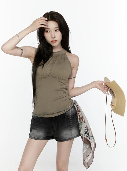 Draped Halter Tank Top IL522 Dark green front model standing three-quarter holding hat and patchwork scarf with chain belt ruched side styling