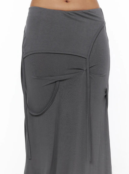 Draped Maxi Skirt CL503 Dark gray close-up detail of folded waistband, curved pocket opening, and center tie knot on model