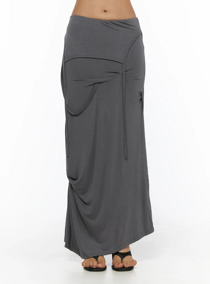 Draped Maxi Skirt CL503 Dark gray front full-body shot on model showing folded waistband, curved pocket, tie strings, and flowy maxi hem