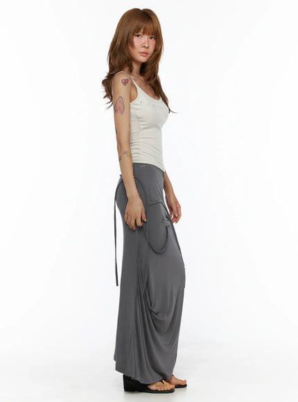 Draped Maxi Skirt CL503 Dark gray side full-body shot on model holding tie strap, showcasing draped maxi length and soft jersey fabric