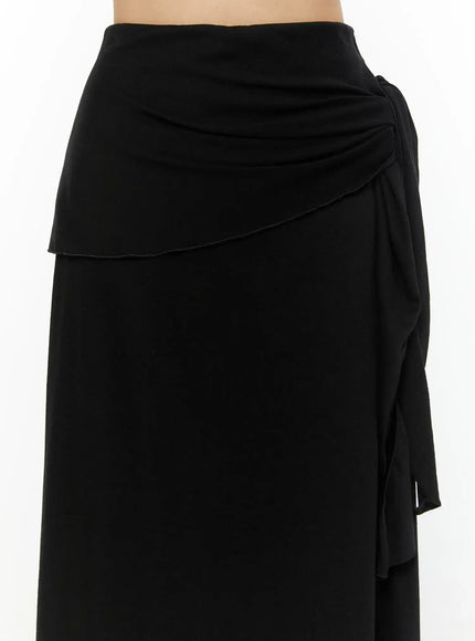 Draped Wrap Maxi Skirt CL520 Black close-up detail of ruched waistband and layered wrap panel with side tie knot