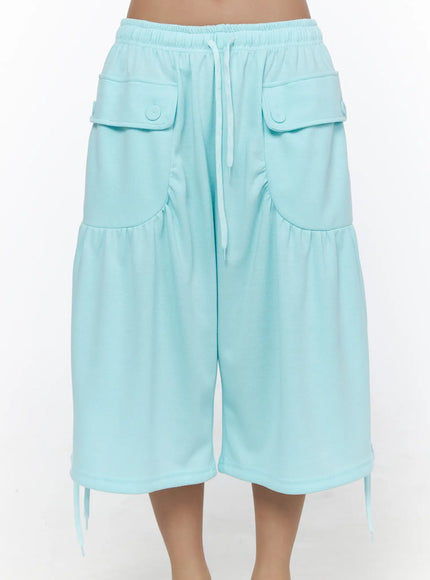 Drawstring Bermuda Shorts CL513 Mint close-up front shot on model showing dual flap button pockets, elastic waistband, drawstring, and gathered hem with tie details