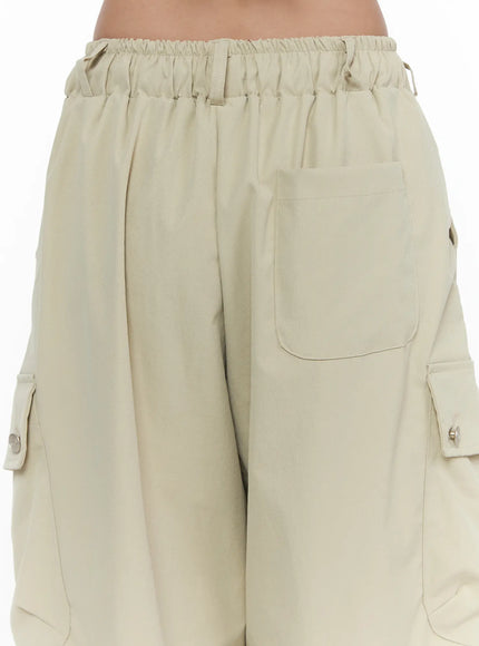 Drawstring Cargo Jorts CL510 Beige close-up back detail shot showing ruched elastic waistband, back patch pocket, and side snap-button cargo pockets