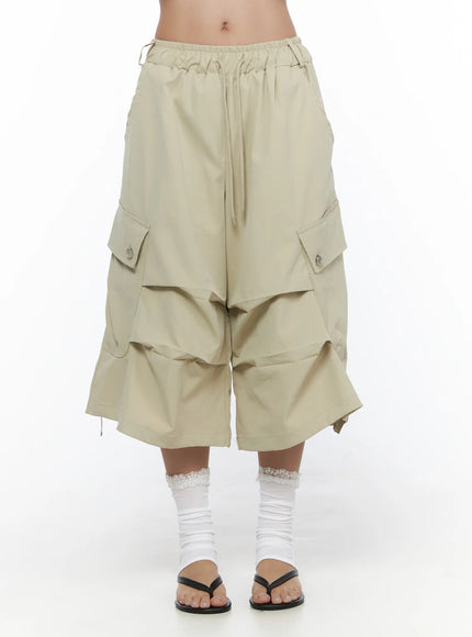 LEWKIN Drawstring Cargo Jorts CL510 Beige front close-up on model showing elastic drawstring waistband and layered wide-leg silhouette with snap-button cargo pockets