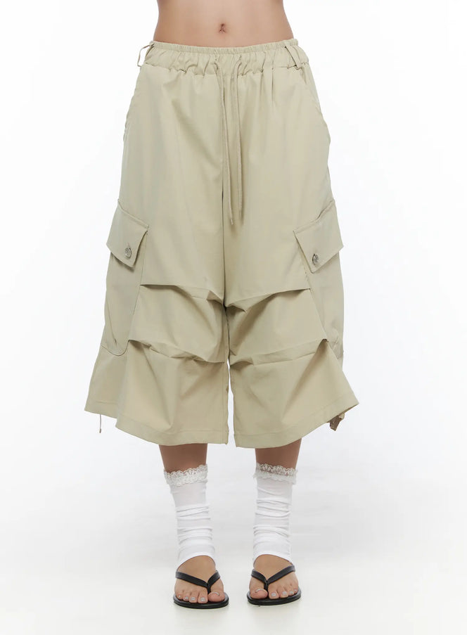 LEWKIN Drawstring Cargo Jorts CL510 Beige front close-up on model showing elastic drawstring waistband and layered wide-leg silhouette with snap-button cargo pockets