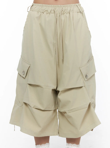 Drawstring Cargo Jorts CL510 Beige front mid-shot on model showing ruched elastic waistband, center drawstring tie, and dual snap-button cargo pockets