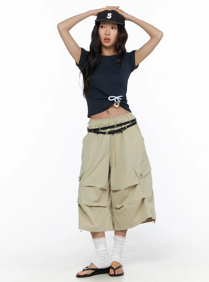 Drawstring Cargo Jorts CL510 Beige full-body front shot on model styled with navy crop tee, studded belt, cap, and white lace socks with black sandals