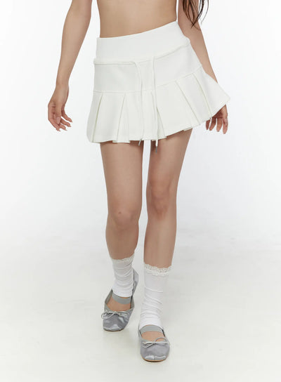 LEWKIN Drawstring Pleated Mini Skirt CL507 White S/M front close-up on model showing pleated hem and drawstring detail with lace socks and ballet flats