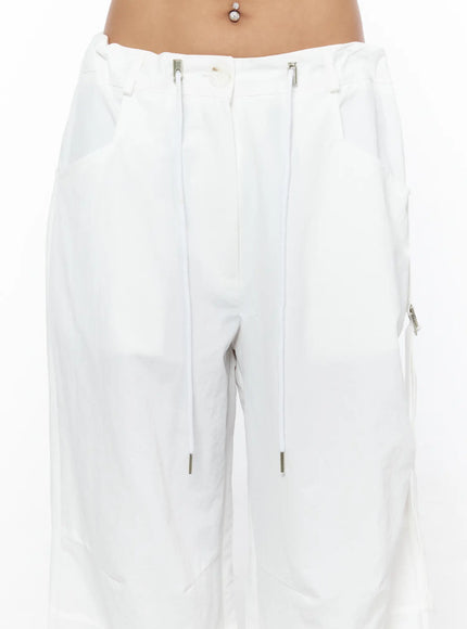 Drawstring Wide Leg Parachute Pants CU524 White close-up detail of waistband showing silver double zip closure drawstring pulls and low-rise fit on model