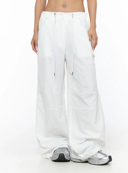 Drawstring Wide Leg Parachute Pants CU524 White front view on model showing full wide leg parachute silhouette with drawstring and zip hardware and sneakers