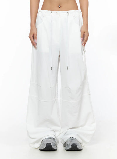LEWKIN Drawstring Wide Leg Parachute Pants CU524 White front view on model cropped at waist showing silver zip hardware and drawstring detail size M/L