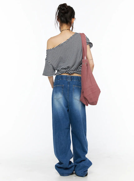 Easton Washed Wide Leg Jeans CU530 Dark blue back full-length styling shot on model wearing striped off-shoulder top and pink tote, showing back pockets, elastic waist, and oversized wide leg