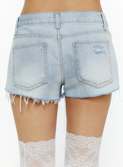 Echo Light-Wash Denim Shorts CL515 light wash close-up back detail shot on model showing dual back pockets frayed raw hem distressed detail and white lace thigh-high socks
