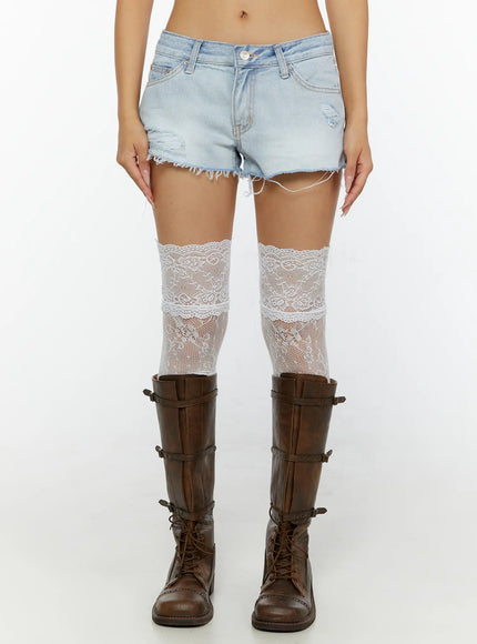 Echo Light-Wash Denim Shorts CL515 light wash front close-up model shot showing low-rise waistband distressed details frayed hem with white lace thigh-high socks and brown boots