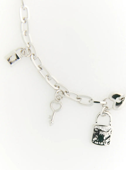 Eden Key Bracelet IL522 silver detail flat lay showing padlock charm heart key charm and oval cable chain links on white background