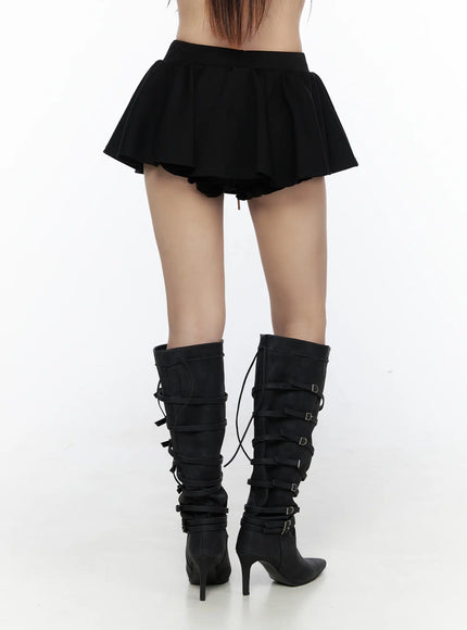 Elastic Waist Tiered Ruffle Mini Skirt CL524 Black back close-up on model, revealing ruffle hem and drawstring waist detail, paired with multi-buckle black knee-high heeled boots