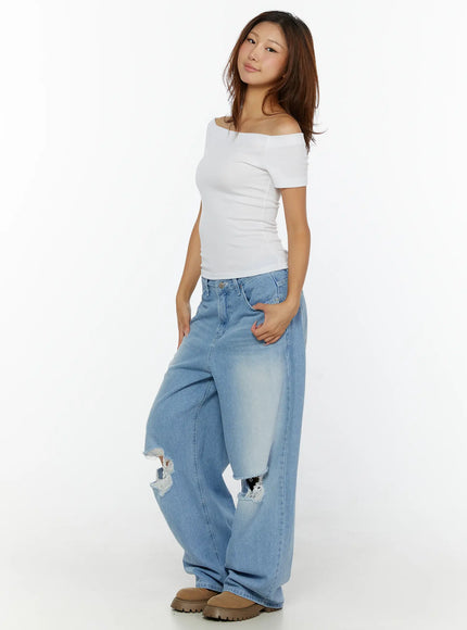 Elvin Low Rise Baggy Ripped Jeans CL515 Light blue three-quarter side shot on model with white top hand in pocket showing ripped knee and wide leg
