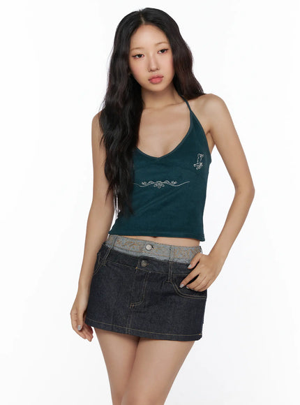 Embroidered Halter Top CL513 Dark green front model three-quarter bust shot V-neck halter silver angel and scrollwork embroidery ribbed knit crop top detail