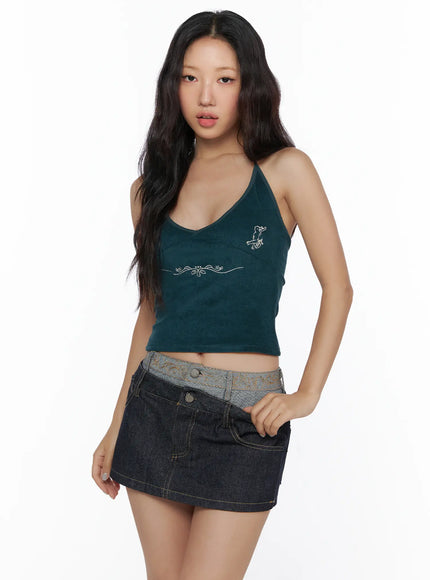 Embroidered Halter Top CL513 Dark green front model three-quarter shot standing hand on hip V-neck halter angel embroidery ribbed crop top denim mini skirt styling
