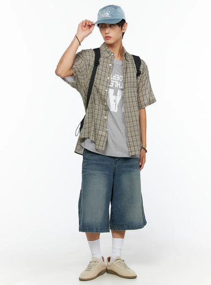 Embroidered Outdoor Cap IL520 Blue full-body front model shot one hand touching brim standing upright with plaid shirt denim shorts backpack