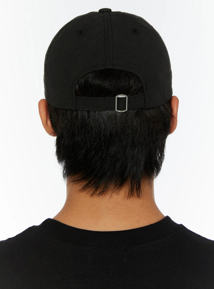 Embroidered Sun Logo Cap IL515 Black back view on model showing silver metal adjustable buckle strap and ventilation eyelets on black cap