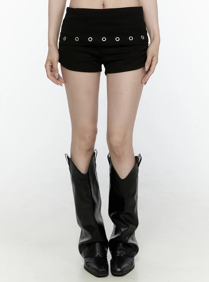 LEWKIN Eyelet Detail Mini Shorts IL522 Black S/M front close-up on model paired with black cowboy boots, silver grommet row detail on ribbed waistband