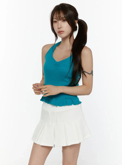 Eyelet Frill Halter Sleeveless Top CL507 Blue three-quarter side view on model with pigtails hands clasped showing V-neckline eyelet knit texture and ruffle hem