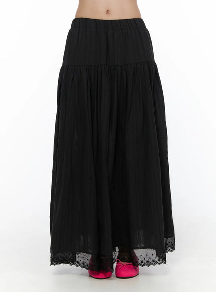 Eyelet Lace Flared Long Skirt CL510 Black front model shot close-up from waist down showing tiered gathers, lightweight crinkle fabric, and eyelet lace hem