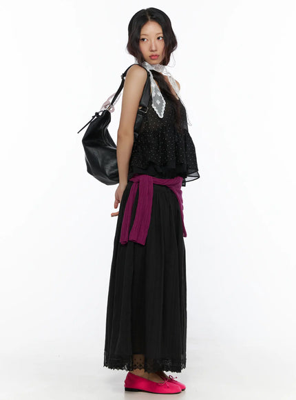 Eyelet Lace Flared Long Skirt CL510 Black side model shot showing flared silhouette with purple knit waist tie, black leather bag, and pink ballet flats