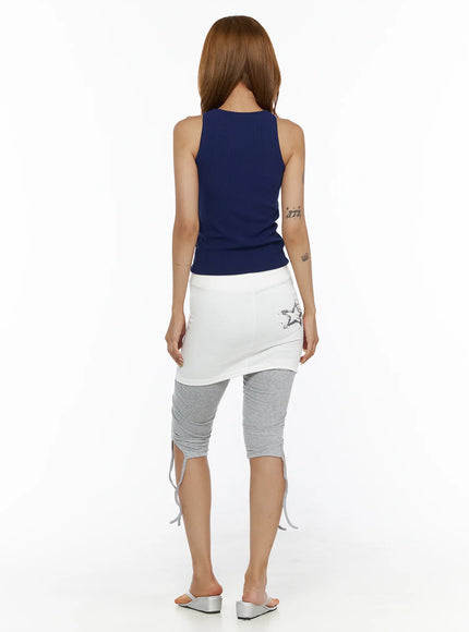 Eyelet Ribbed Tank Top CL503 Dark blue back view on model, ribbed knit sleeveless crop top with racerback silhouette, styled with white graphic skirt and gray capri leggings