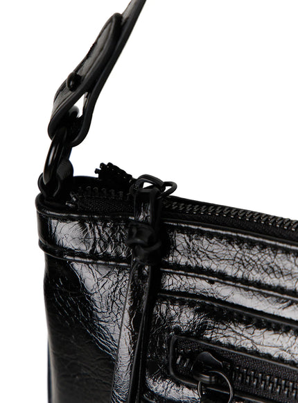 Faux Leather Crossbody CL517 Black close-up detail top-left corner showing matte black zipper pull adjustable strap hardware and crinkled patent leather texture