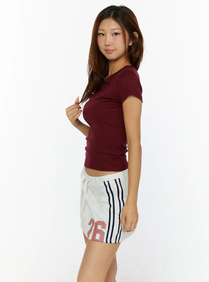Fitted Crop Top CL515 burgundy side view on model wearing sport shorts showing slim silhouette and short sleeve crop length