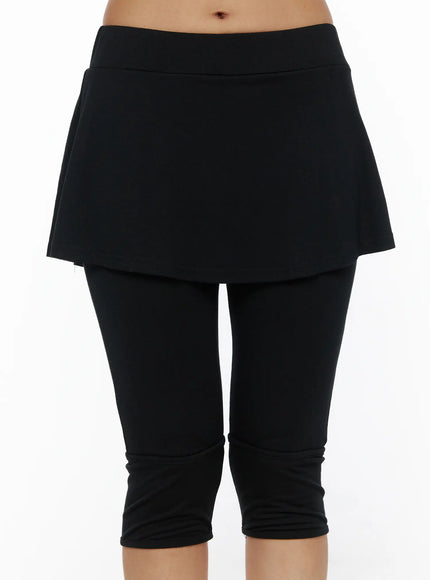 Flare Skort CL503 Black close-up front shot on model showing wide waistband detail and A-line skirt overlay above fitted capri leggings without shoes