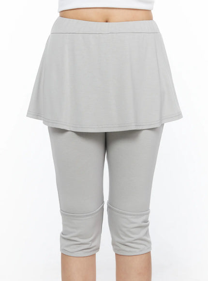 Flare Skort CL517 Light gray close-up front view on model, cropped waist-to-ankle shot showing flared skirt overlay, elastic waistband, and banded capri legging detail
