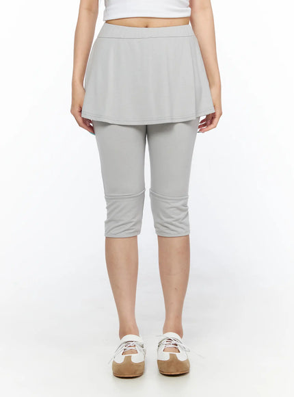 Flare Skort CL517 Light gray front view on model, full waist-to-ankle shot showing flared skirt silhouette over capri leggings, hands at sides, white sneakers