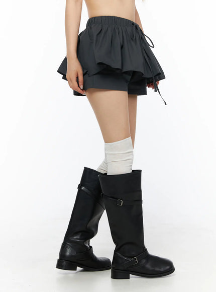 Flared Mini Skort CL501 Dark gray side view close-up on model showing layered ruffle hem, drawstring detail and inner shorts with black knee boots