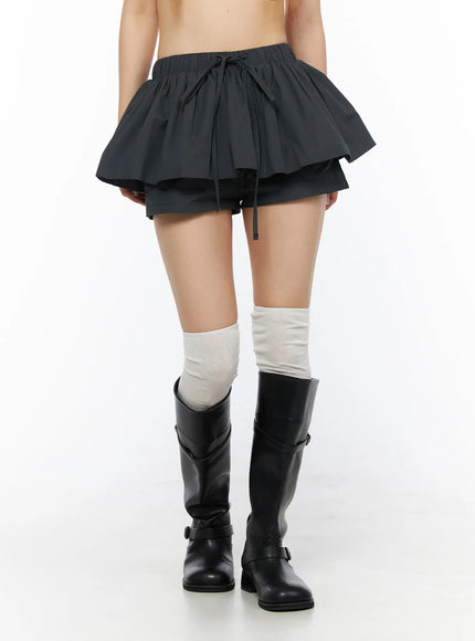 Flared Mini Skort CL501 Dark gray front view on model cropped at waist, highlighting voluminous tiered ruffle skirt layer, drawstring tie and inner shorts
