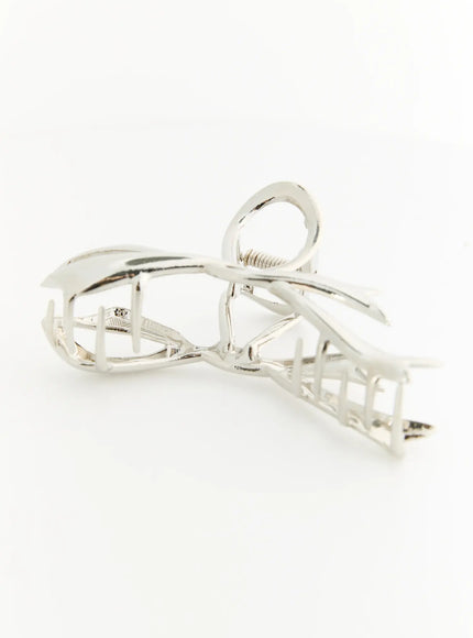 Flora Silvr Ribbon Hair Clip IL503 silver side detail view displaying inner claw teeth grid spring coil and sculptural ribbon frame