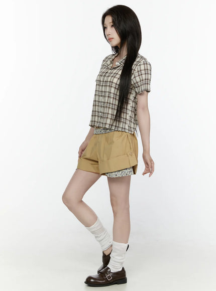 Floral Banded Shorts IL521 Beige back full-length shot on model in plaid crop shirt with arm extended, floral inner layer and loafers