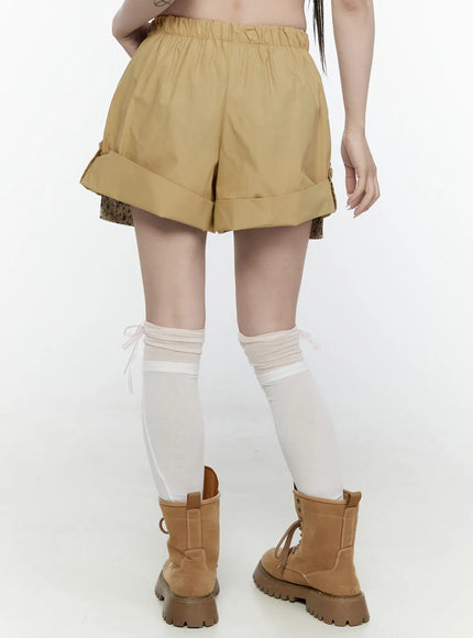 Floral Banded Shorts IL521 Beige back shot on model showing elastic waistband, cuffed hem with side buttons, and floral inner layer with boots