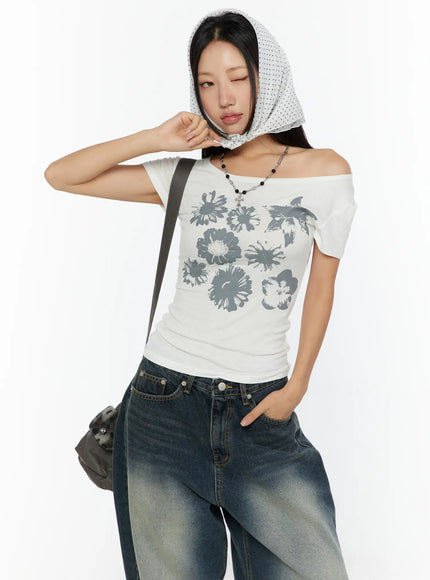 LEWKIN Floral Graphic Round-Shoulder Top CU529 White front shot on model wearing polka-dot head scarf, off-shoulder styling, gray floral print, ribbed cotton