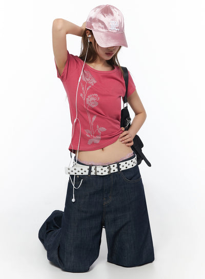 LEWKIN Floral Graphic Short Sleeve Top IU525 Dark pink kneeling model front shot styled with pink satin cap earphones crossbody bag star belt wide-leg jeans