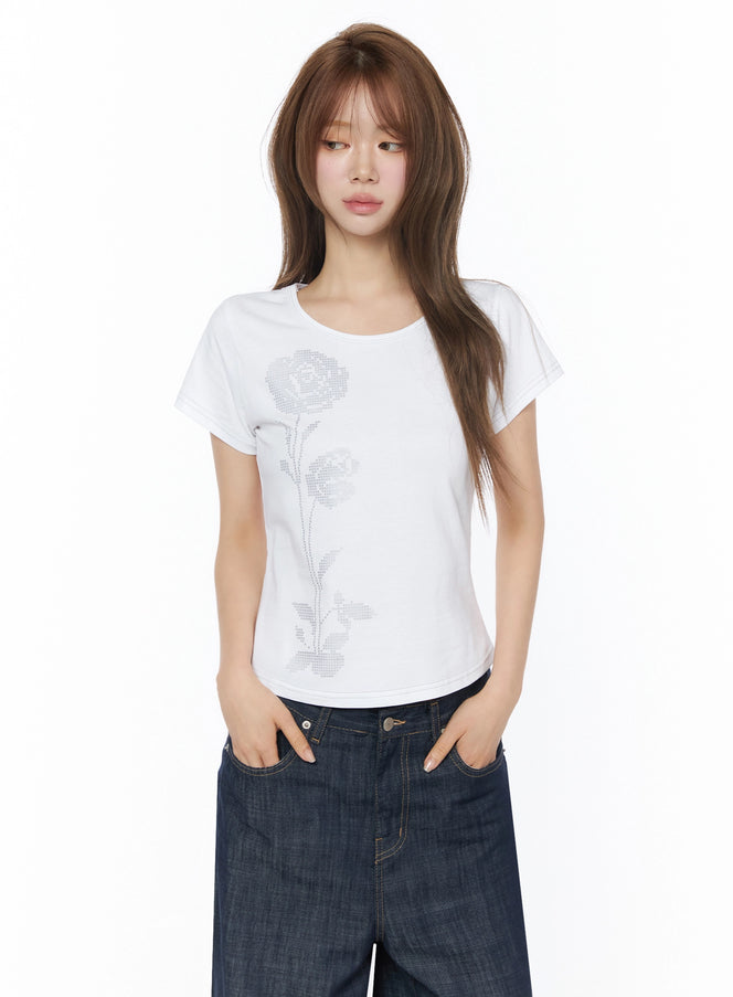 Floral Graphic Short Sleeve Top IU525 White front shot model hands in pockets paired with wide-leg dark denim cross-stitch rose graphic cotton tee